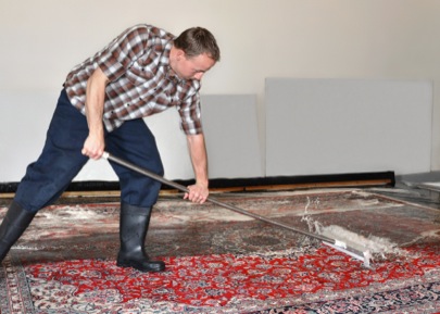 Picture of member of Imperial Rug Cleaning team cleaning a rug